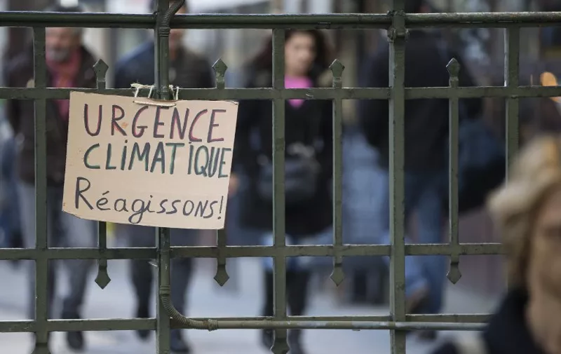 A cardboard placard reading "Climatic Emergency, Let's React" attached to an underground station railings is pictured in downtown Paris on December 4, 2015, within the COP21 United Nations Conference on Climate change.
Delegates from 195 countries at UN climate talks are bogged down by core difference and textual wrangling as they draft a global pact to beat back the threat of global warming. / AFP / JOEL SAGET
