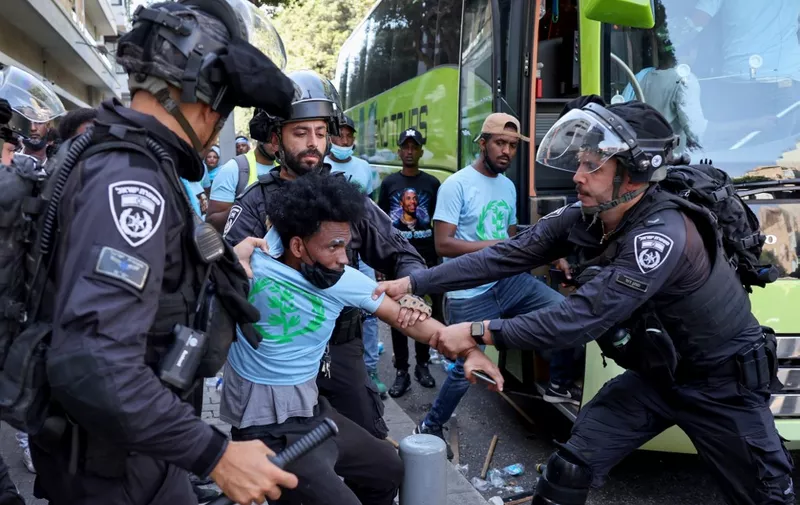 Members of Israel's security forces clash with Eritrean asylum-seekers protesting an event organised by Eritrea's government in the coastal city of Tel Aviv on September 2, 2023. A dozen Eritrean asylum seekers were wounded by Israeli police gunfire on Sptember 2 after a demonstration against an Eritrean government event turned violent, police and medical sources said. (Photo by JACK GUEZ / AFP)