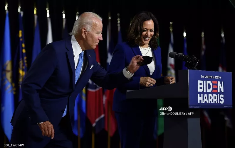 Democratic presidential nominee and former US Vice President Joe Biden grabs his mask afte rintroducing his vice presidential running mate, US Senator Kamala Harris, during their first press conference together in Wilmington, Delaware, on August 12, 2020. (Photo by Olivier DOULIERY / AFP)