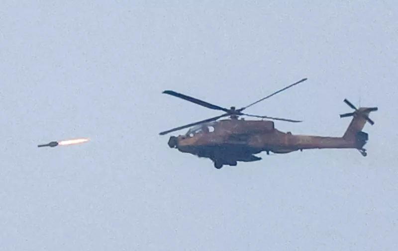 An Israeli air force attack helicopter fires a missile while flying over the northern Gaza Strip near the border with southern Israel on December 17, 2023 amid continuing battles between Israel and the militant group Hamas. (Photo by JACK GUEZ / AFP)
