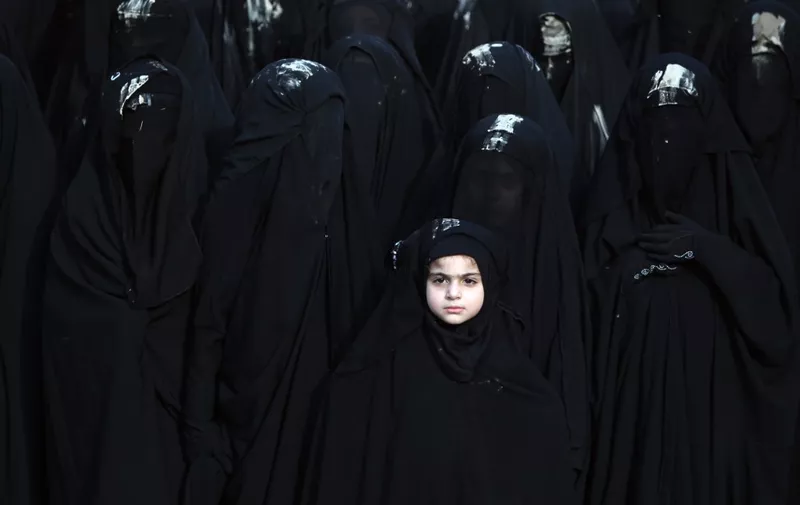 Iraqi Shiite girls, whose face is covered with a veil, take part in a parade ahead of Ashura in Baghdad's northern district of Kadhimiya on October 23, 2015. Ashura mourns the death of Imam Hussein, a grandson of the Prophet Mohammed, who was killed by armies of the Yazid near Karbala in 680 AD. AFP PHOTO / AHMAD AL-RUBAYE (Photo by AHMAD AL-RUBAYE / AFP)