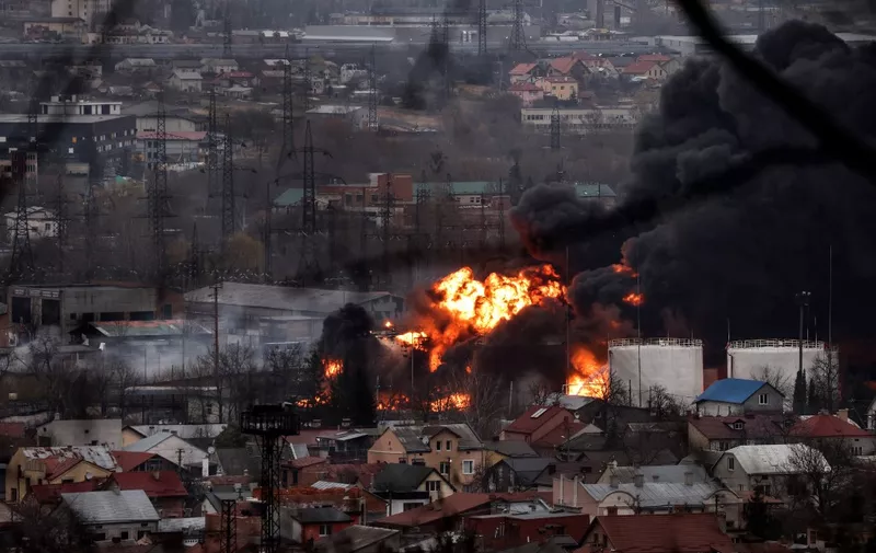Dark smoke and flames rise from a fire following an air strike in the western Ukrainian city of Lviv, on March 26, 2022. - At least five people wounded in two strikes on Lviv, the regional governor said, in a rare attack on a city that has escaped serious fighting since Russian troops invaded last month. (Photo by Ronaldo SCHEMIDT and RONALDO SCHEMIDT / AFP)
