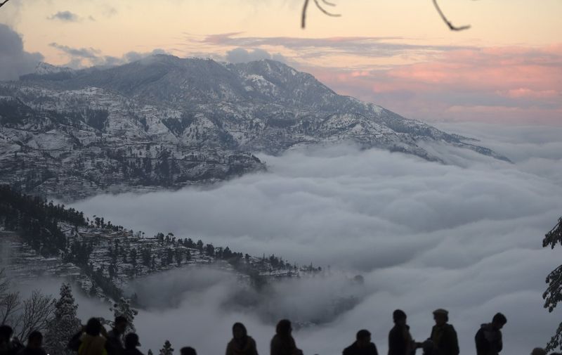 Tourist gather at a view point during a snowfall in Murree, some 65 km north of Islamabad on January 7, 2020. (Photo by Aamir QURESHI / AFP)
