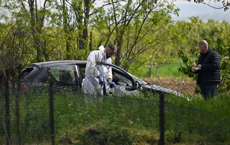 A forensic investigator works at one of the crime scenes, outside of the village of Dubona near the town of Mladenovac, about 60 kilometres (37 miles) south of Serbia's capital Belgrade, on May 5, 2023, in the aftermath of a drive-by shooting. Police arrested a suspected gunman responsible for killing eight people and injuring 13 others, state media reported early on May 5, 2023, following an hours-long manhunt throughout the night in the country's second mass shooting this week. (Photo by ANDREJ ISAKOVIC / AFP)