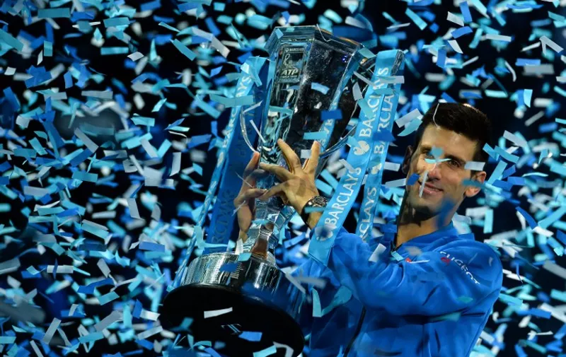 Serbia's Novak Djokovic holds up the ATP trophy after winning the men's singles final match against Switzerland's Roger Federer on day eight of the ATP World Tour Finals tennis tournament in London on November 22, 2015. 
AFP PHOTO / GLYN KIRK / AFP / GLYN KIRK