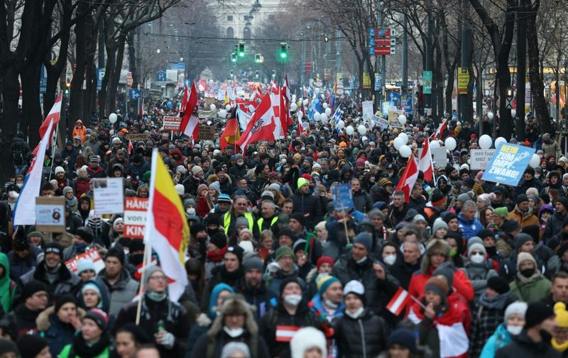 People carry Austrian flags as they demonstrate against the Austrian government's measures taken in order to limit the spread of the coronavirus during a protest on January 8, 2022 in Vienna, amid the novel coronavirus / COVID-19 pandemic. (Photo by FLORIAN WIESER / APA / AFP) / Austria OUT