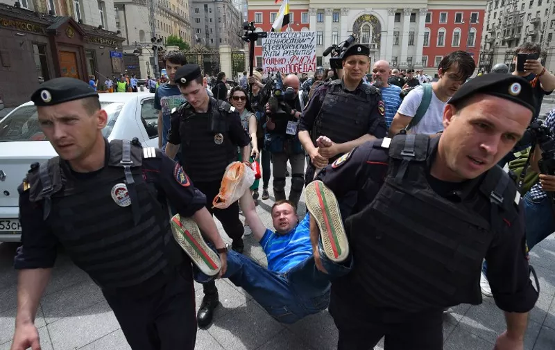 Russian riot policemen detain gay and LGBT rights activist Nikolai Alexeyev (C) during an unauthorized gay rights activists rally in central Moscow on May 30, 2015. Moscow city authorities turned down demands for a gay rights rally. AFP PHOTO/DMITRY SEREBRYAKOV