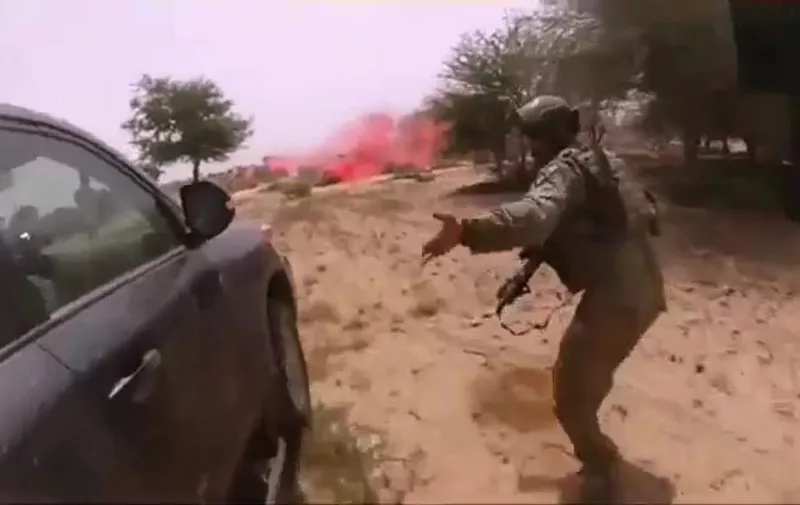 This video screen grab obtained March 5, 2018 courtesy of Nashir News Agency (ISIS affiliated propaganda media),shows purportedly the October 4, 2017, ambush of American and Nigerien soldiers in Tongo Tongo, Niger. - A propaganda video released by the Islamic State group showing the deadly ambush of US troops in Niger raised fresh questions Monday as to the nature of the mission and why the soldiers had been left so vulnerable. The distressing video, distributed by a pro-IS news agency, includes graphic footage taken by a solder wearing a helmet camera. It shows the chaos of the attack, including the solider wearing the camera being shot dead, with apparent IS fighters stalking past his body.The Defense Department "is aware of alleged photos and IS propaganda video from the October 4, 2017 terrorist attack in Niger. The release of these materials demonstrates the depravity of the enemy we are fighting," the Pentagon said in a statement.The nine-minute video, set to Islamic chanting, includes an image of IS leader Abu Bakr al-Baghdadi and footage of pick-up trucks rolling through a desert landscape. (Photo by Handout / Nashir News Agency / AFP) / RESTRICTED TO EDITORIAL USE - MANDATORY CREDIT "AFP PHOTO / NASHIR NEWS AGENCY/HANDOUT" - NO MARKETING NO ADVERTISING CAMPAIGNS - DISTRIBUTED AS A SERVICE TO CLIENTS