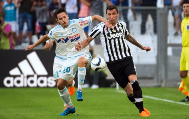 Marseille's French midfielder Florian Thauvin (L) vies for the ball  with Juventus' Croatian midfielder Mario Mandzukic during  the Robert Louis-Dreyfus Trophy football friendly match Olympique de Marseille vs Juventus on August 1, 2015 at the Velodrome stadium in Marseille, southeastern France. AFP PHOTO / BERTRAND LANGLOIS