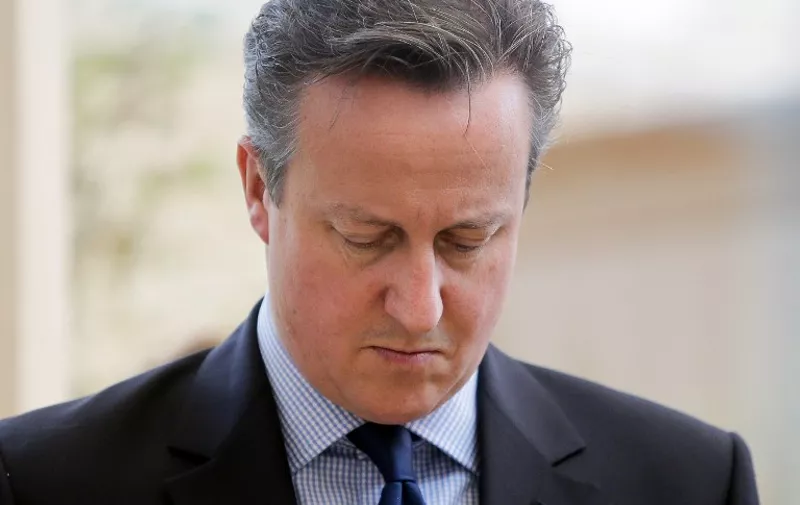 British Prime Minister David Cameron observes a minute's silence during a visit to a Health Centre in his constituency in Witney, central England, on July 3, 2015. Britain's Queen Elizabeth II and Prime Minister David Cameron led a nationwide minute's silence on Friday, a week after a jihadist gun massacre in Tunisia in which 30 out of the 38 victims were Britons.  AFP PHOTO / POOL / DANIEL LEAL-OLIVAS