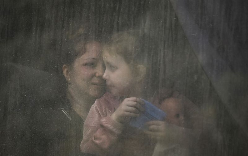 A mother with her daughter sit inside a bus as they evacuate the city of Bakhmut at the eastern Ukranian region of Donbas on May 22, 2022, amid Russian invasion of Ukraine. (Photo by ARIS MESSINIS / AFP)