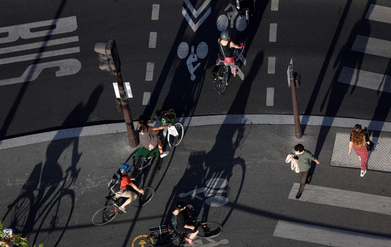 A picture taken in Paris, on July 9, 2020, shows cyclists on the Place de la Bastille in Paris. (Photo by Thomas SAMSON / AFP)