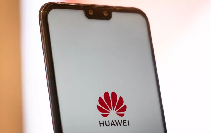 A Huawei logo is displayed on a smartphone at a retail store in Beijing on May 23, 2019. - Chinese telecom giant Huawei says it could roll out its own operating system for smartphones and laptops in China by the autumn after the United States blacklisted the company, a report said on May 23. (Photo by FRED DUFOUR / AFP)
