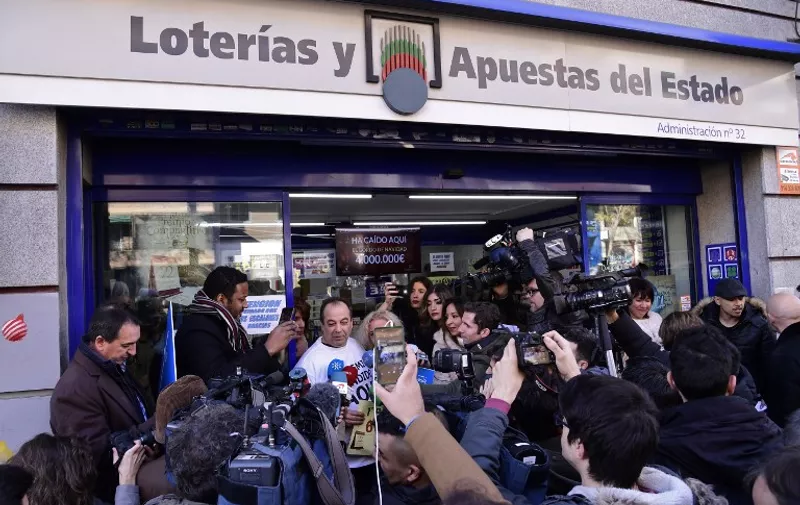Spanish Administration Lottery owner Agustin (CL) answers to journalists as he celebrates having sold the first prize ticket (66513) of Spain's Christmas lottery named "El Gordo" (Fat One) in the Embajadores neighbourhood in Madrid, on December 22, 2016.
The Gordo lottery first took place in 1812 in Cadiz and has not missed a year since, continuing through Spains civil war between 1936 and 1939. In 1938, there were actually two Christmas lotteries, one held in Burgos by dictator General Francos Nationalist regime, and the other in Republican-ruled Barcelona. / AFP PHOTO / JAVIER SORIANO