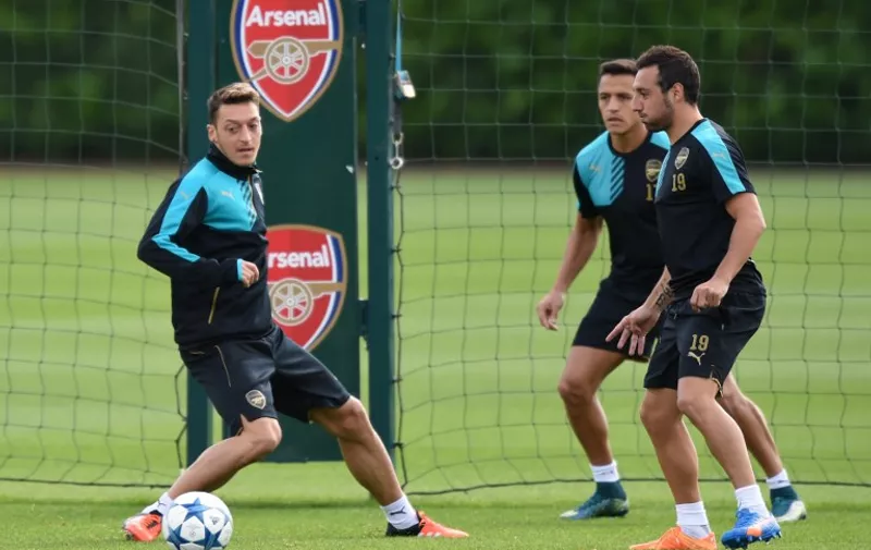 Arsenal's German midfielder Mesut Ozil (L) trains with Spanish midfielder Santi Cazorla and Chilean striker Alexis Sanchez at London Colney training ground in St Albans, north London on 28 September, 2015 before a Group F Champions League football match against Olympiakos.  
 / AFP / OLLY GREENWOOD