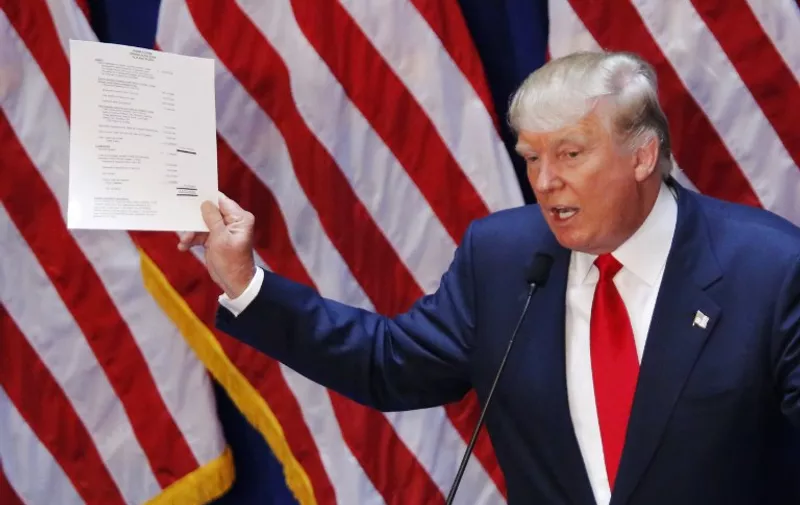 Real estate investor Donald Trump displays his financial statement during his announcement that he will run for the 2016 presidential election at the Trump Tower in New York  on June 16, 2015. Trump, one of America's most flamboyant and outspoken billionaires, threw his hat into the race Tuesday for the White House, promising to make America great again. The 69-year-old long-shot candidate ridiculed the country's current crop of politicians and vowed to take on the growing might of China in a speech launching his run for the presidency in 2016. "I am officially running for president of the United States and we are going to make our country great again," he said from a podium bedecked in US flags at Trump Tower on New York's Fifth Avenue.   AFP PHOTO/ KENA BENTACUR