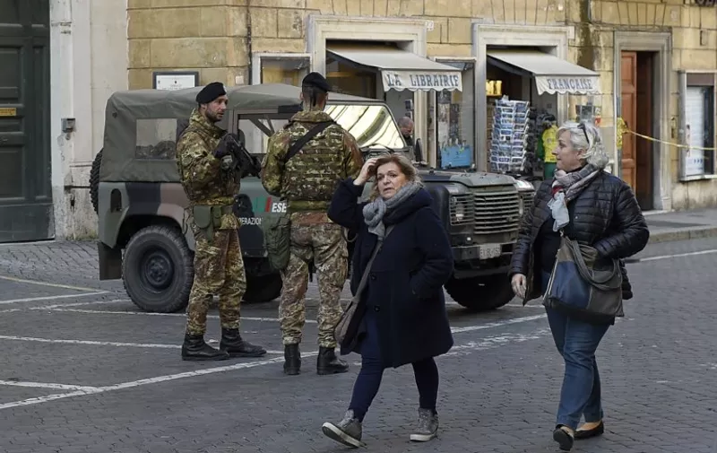 Italian soldiers patrol on November 28, 2015 in Rome. Italy is to spend an additional one billion euros ($1.06 billion) on security, Italian Prime Minister Matteo Renzi announcedon 25 november. In a speech at Rome city hall, he said 500 million euros would be earmarked for cyber-security and modernising the police force, and 500 million for the Italian armed forces. Another billion euros will also be spent on culture and sport, as "we have to remember who we are," Renzi said. AFP PHOTO / ANDREAS SOLARO / AFP / ANDREAS SOLARO