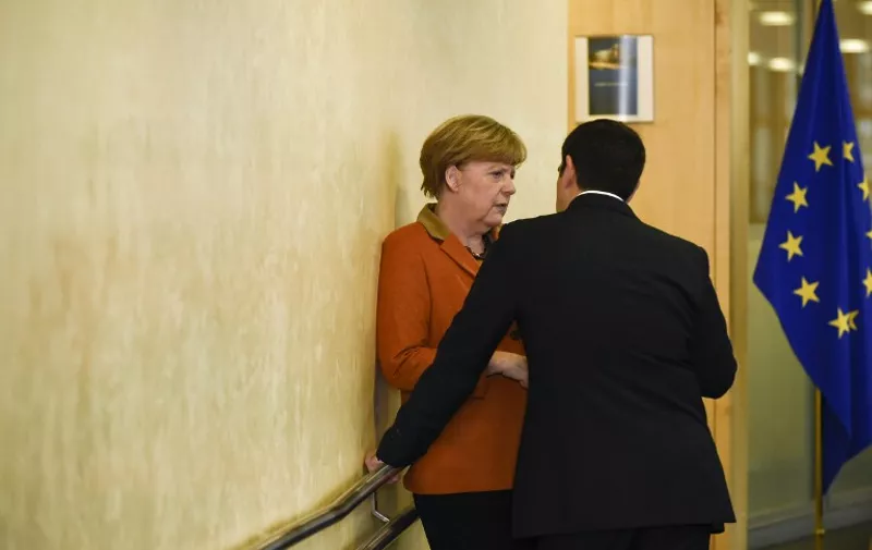 Greek Prime Minister Alexis Tsipras (R) speaks to German Chancellor Angela Merkel ahead of an EU-Balkans mini summit at the EU headquarters in Brussels on October 25, 2015. European Union and Balkan leaders faced a make-or-break summit on the deepening refugee crisis after three frontline states threatened to close their borders if their EU peers stopped accepting migrants. AFP PHOTO / JOHN THYS