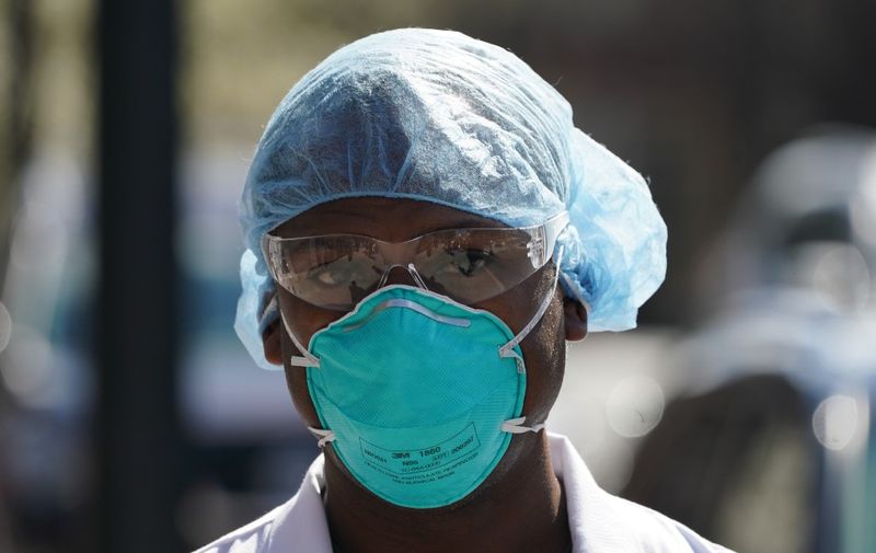 A member of the medical staff listens as Montefiore Medical Center nurses call for N95 masks and other critical PPE to handle the coronavirus (COVID-19) pandemic on April 1, 2020 in New York. - The nurses claim "hospital management is asking nurses to reuse disposable N95s after long shifts" in the Bronx. (Photo by Bryan R. Smith / AFP)