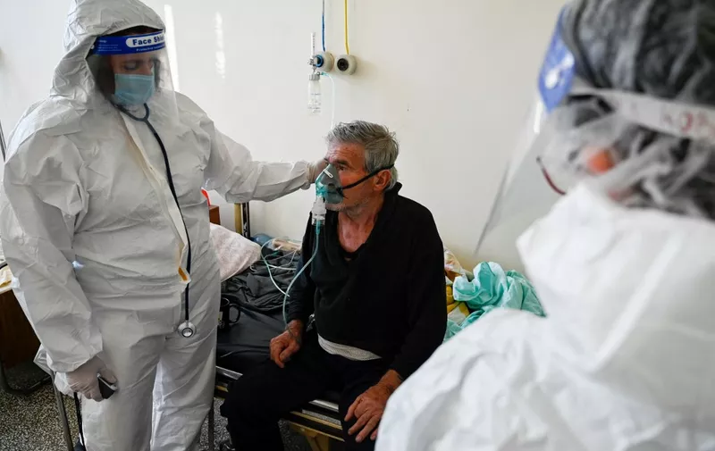 A doctor examines a patient at the Covid-19 unit of a hospital in Kjustendil on October 19, 2021, one of the municipalities in the 'dark Red Covid zone' of Bulgaria, where more than 500 people out of every 100,000 are infected with coronavirus (Covid-19). - Hospitals in the Balkan country are brimming with patients amid soaring new coronavirus infections over the past days. The government will discuss new measures, possibly introducing a green certificate for public venues such as night clubs, restaurants, cinemas, theatres, fitness clubs and others, in order to avoid new closures of businesses. (Photo by Nikolay DOYCHINOV / AFP)