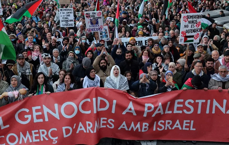 Protesters hold a banner reading 'Stop genocide in Palestine and sale of weapon with Israel' during a rally in support of the people from Gaza, in the Palestinian territories, in Barcelona on January 20, 2024. Thousands of civilians, both Palestinians and Israelis, have died since October 7, 2023, after Palestinian Hamas militants based in the Gaza Strip entered southern Israel killing 1,200 people and took 240 people hostage, Israel says, in an unprecedented attack triggering a war declared by Israel on Hamas with retaliatory bombings on Gaza. (Photo by LLUIS GENE / AFP)