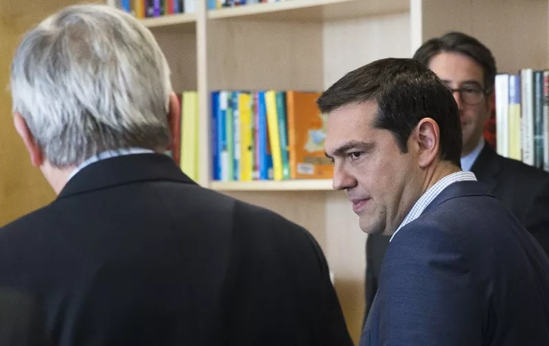 Greece's Prime Minister Alexis Tsipras (R) is welcomed by European Commission President Jean-Claude Juncker (L) ahead of a meeting on Greece, at the European Commission in Brussels, on June 24, 2015, as eurozone finance ministers try to finalise a debt deal and avoid a default by Athens. Greek Prime Minister Alexis Tsipras is set to conduct yet another round of crisis talks with representatives of the country's creditors, ahead of a crucial meeting of eurozone finance ministers where all sides hope a solution can be found to save the country from bankruptcy. AFP PHOTO / POOL / JULIEN WARNAND
