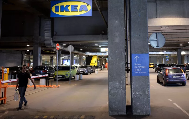A pedestrian walks under a logo of Swedish retailer Ikea at an underground parking lot in a shopping mall in Moscow on August 9, 2022. - On February 24 Russia started military action in Ukraine triggering unprecedented Western sanctions against Moscow and sparking an exodus of foreign corporations including H&amp;M, Zara, Uniqlo, McDonald's and Ikea. Ikea will finish its final online sale in Russia on August 15, local media reported. (Photo by Kirill KUDRYAVTSEV / AFP)