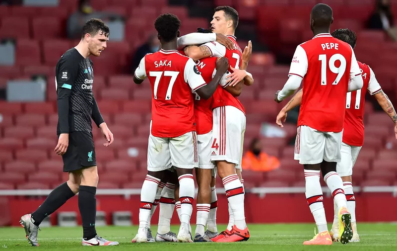 LONDON, ENGLAND - JULY 15: Reiss Nelson of Arsenal celebrates with teammates after scoring his sides second goal during the Premier League match between Arsenal FC and Liverpool FC at Emirates Stadium on July 15, 2020 in London, England. Football Stadiums around Europe remain empty due to the Coronavirus Pandemic as Government social distancing laws prohibit fans inside venues resulting in all fixtures being played behind closed doors. (Photo by Glyn Kirk/Pool via Getty Images)
