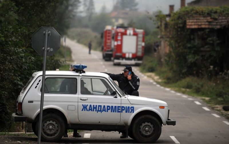 Police officers stay guard on the road to Explosives decommissioning plant  near the northwestern village of Gorni Lom, on October 2, 2014. Fifteen people were confirmed dead in a blast that flattened a Bulgarian explosives decommissioning plant near the northwestern village of Gorni Lom the previous day, officials said. AFP PHOTO / NIKOLAY DOYCHINOV