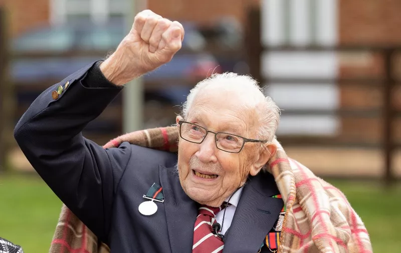 A handout picture released on April 30, 2020 shows Captain Tom Moore waving at a flypast by Battle of Britain Memorial planes to celebrate his 100th birthday in Marston Moretaine. (Photo by Emma SOHL / CAPTURE THE LIGHT / AFP) / RESTRICTED TO EDITORIAL USE - MANDATORY CREDIT "AFP PHOTO / CAPTURE THE LIGHT / EMMA SOHL" - NO MARKETING NO ADVERTISING CAMPAIGNS - DISTRIBUTED AS A SERVICE TO CLIENTS --- NO ARCHIVE ---