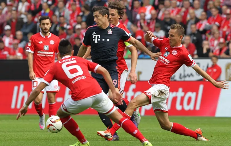 Bayern Munich's Polish striker Robert Lewandowski (C) is pressured by Mainz' midfielder Danny Latza (L) and Mainz' defender Niko Bungert (R) vie for the ball during the German first division Bundesliga football match 1 FSV Mainz 05 vs FC Bayern Muenchen in Mainz, southern Germany, on September 26, 2015. AFP PHOTO / DANIEL ROLAND 
RESTRICTIONS: DURING MATCH TIME: DFL RULES TO LIMIT THE ONLINE USAGE TO 15 PICTURES PER MATCH AND FORBID IMAGE SEQUENCES TO SIMULATE VIDEO. 
== RESTRICTED TO EDITORIAL USE ==
FOR FURTHER QUERIES PLEASE CONTACT DFL DIRECTLY AT + 49 69 650050.