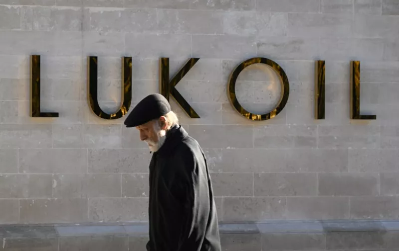 A man walks past the headquarters of Russia's oil producer Lukoil in Moscow on October 10, 2022. (Photo by NATALIA KOLESNIKOVA / AFP)