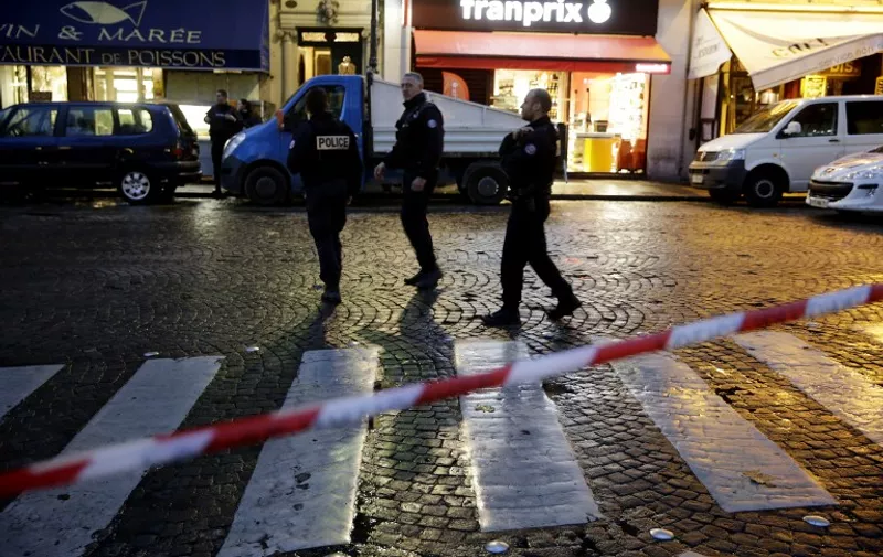 Police man a cordon in central Paris on November 17, 2015 as security operations continue in the wake of the November 13, 2015 terror attacks in which at least 129 people were killed.   AFP PHOTO / KENZO TRIBOUILLARD