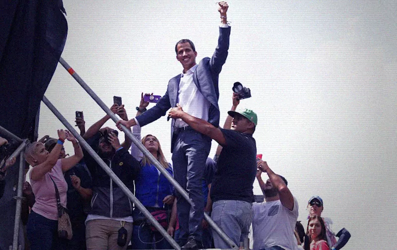 Opposition leader Juan Guaido gestures at thousands of supporters during a gathering in Caracas on February 2, 2019. - Tens of thousands of protesters were set to pour onto the streets of Caracas to back self-proclaimed acting president Guaido's calls for early elections as international pressure increased on President Nicolas Maduro to step down. Major European countries have set a Sunday deadline for Maduro to call snap presidential elections. (Photo by Juan BARRETO / AFP)