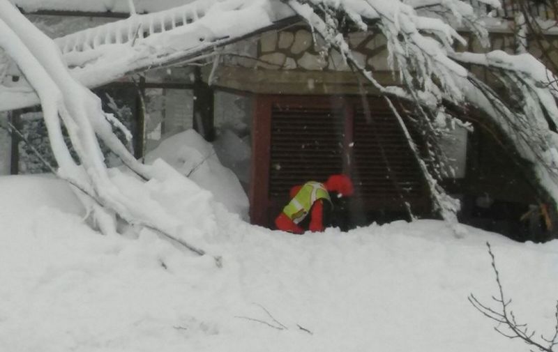 A handout picture released on January 21, 2017 by the Corpo Nazionale Soccorso Alpino e Speleologico (CNSAS) shows a rescuer digging at by the avalanche-hit Hotel Rigopiano, near the village of Farindola, on the eastern lower slopes of the Gran Sasso mountain on January 19, 2017.
Italian rescuers pulled four survivors from the hotel and said they remained hopeful of finding alive at least some of the 23 people still trapped under the ruins.  / AFP PHOTO / CNSAS / Handout / RESTRICTED TO EDITORIAL USE - MANDATORY CREDIT "AFP PHOTO / CNSAS " - NO MARKETING NO ADVERTISING CAMPAIGNS - DISTRIBUTED AS A SERVICE TO CLIENTS