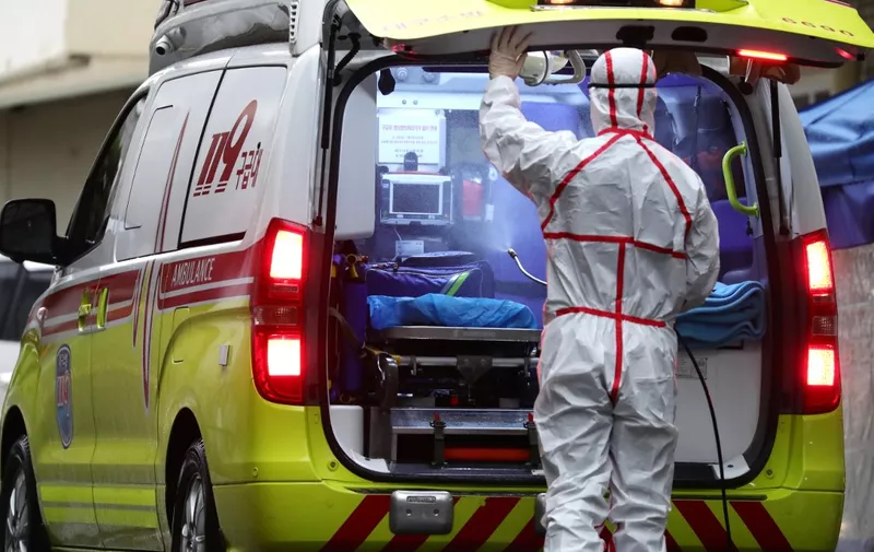 A medical worker sprays disinfectant into an ambulance at a hospital where patients infected with the COVID-19 coronavirus are being treated, in the southeastern city of Daegu on February 25, 2020. - The novel coronavirus outbreak in South Korea is "very grave", President Moon Jae-in said on February 25 as he visited its epicentre and the country's total number of cases approached 1,000. (Photo by - / YONHAP / AFP) / - South Korea OUT / REPUBLIC OF KOREA OUT  NO ARCHIVES  RESTRICTED TO SUBSCRIPTION USE