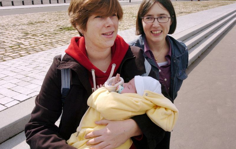 Elodie (G) et Karine, un couple d'homosexuelles, arrivent au palais de Justice de Nantes, le 20 mars 2006, pour prendre conaissance du délibéré du tribunal des affaires de sécurité sociale (Tass). Les deux homosexuelles, mères d'un petit garçon de 21 mois et d'une petite fille de 15 jours, qui réclamaient le droit au congé paternité ont été déboutées. Elodie et Karine, âgées de 29 et 31 ans, ont accueilli sans suprise ce jugement auquel elles s'attendaient. Elles ont un mois pour décider de faire ou non appel de la décision. AFP PHOTO FRANK PERRY (Photo by FRANK PERRY / AFP)
