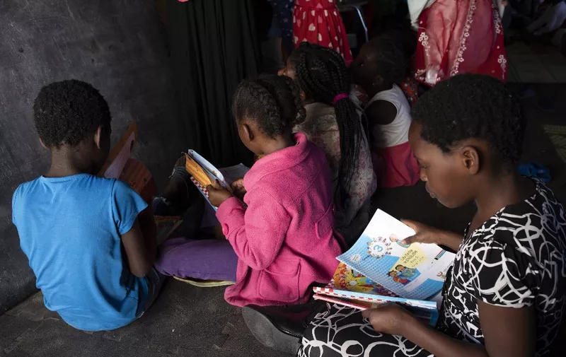 Children attend a makeshift school in a tent, which is part of a group of about 630 people, refugees originally from Democratic Republic of Congo, Rwanda, Burundi, and Bangladesh, and other countries who are sleeping in a large tent in Bellville, Cape Town, on September 22, 2020. - These are some of the asylum seekers, mainly from African countries such as Democratic Republic of Congo and Burundi, that started camping outside the Cape Town offices of the United Nations High Commissioner for Refugees (UNHCR) in October 2019, asking the UN to relocate them to another country and claiming they no longer felt safe in South Africa following a wave of xenophobic attacks.
Later on they were taken in by the Methodist Church from where they were later evicted with authorities citing a coronavirus lockdown to justify the action. (Photo by RODGER BOSCH / AFP)