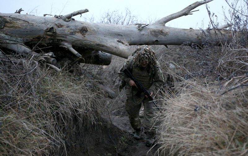 A Ukrainian serviceman walks at a position on the frontline with Russia-backed separatists near the village of Pesky, Donetsk region, on December 14, 2021. (Photo by Anatolii STEPANOV / AFP)