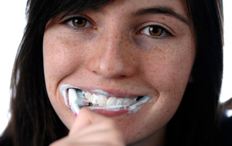 Young woman is brushing her teeth. (Photo by BECKER &amp; BREDEL / Picture Alliance / dpa Picture-Alliance via AFP)
