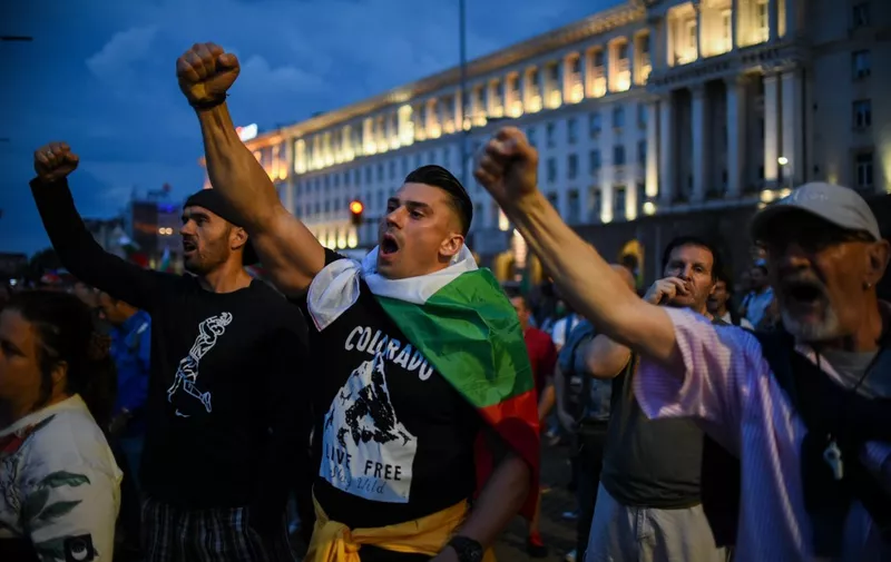 Protesters raise their fist and shout slogans during an anti-government demo in Sofia, on August 7, 2020. - Bulgarian police on August 7, cleared traffic blockades set up by protesters in Sofia and other cities for the past week to demand the resignation of the government over corruption, the interior ministry said. The protesters had occupied three major crossroads in downtown Sofia since July 29 and August 1 as part of the biggest protest wave in years in the EU's poorest country. (Photo by NIKOLAY DOYCHINOV / AFP)
