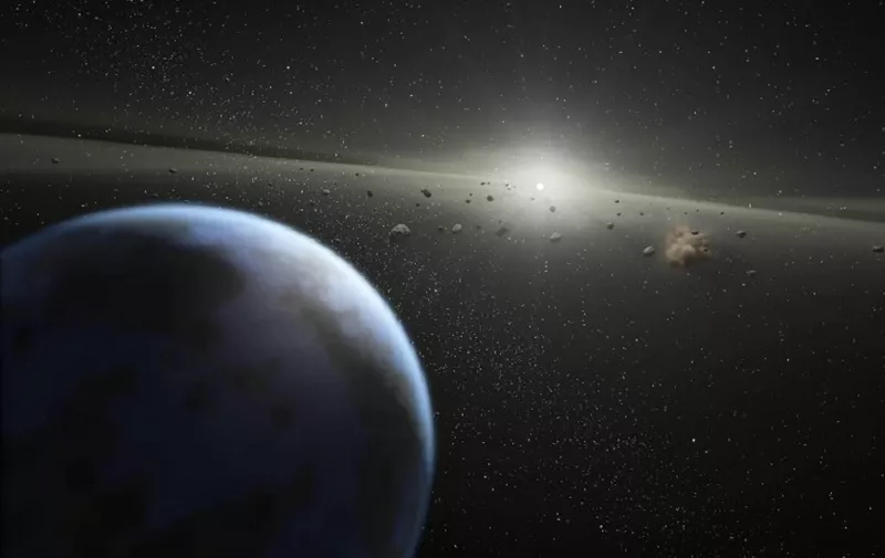This artist's rendition released 20 April, 2005 by NASA shows a massive asteroid belt in orbit around a star the same age and size as our Sun. Evidence for this possible belt was discovered by NASA's Spitzer Space Telescope when it spotted warm dust around the star, presumably from asteroids smashing together. The view starts from outside the belt, where planets like the one shown here might possibly reside, then moves into to the dusty belt itself. A collision between two asteroids is depicted near the end of the movie. Collisions like this replenish the dust in the asteroid belt, making it detectable to Spitzer. The alien belt circles a faint, nearby star called HD 69830 located 41 light-years away in the constellation Puppis. Compared to our own solar system's asteroid belt, this one is larger and closer to its star - it is 25 times as massive, and lies just inside an orbit equivalent to that of Venus. Our asteroid belt circles between the orbits of Mars and Jupiter.   AFP PHOTO/HO/NASA