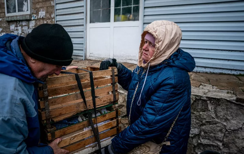 64-year-old Olena and her husband fix boxes on her bicycle in Chasiv Yar, eastern Ukraine, on January 5, 2023, amid the Russian invasion of Ukraine. (Photo by Dimitar DILKOFF / AFP)