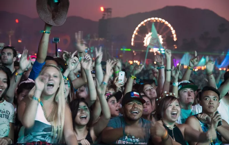 Festival-goers react as US DJ Kaskade performs on day three of the Coachella Music Festival in Indio, California, April 12, 2015. AFP PHOTO / ROBYN BECK