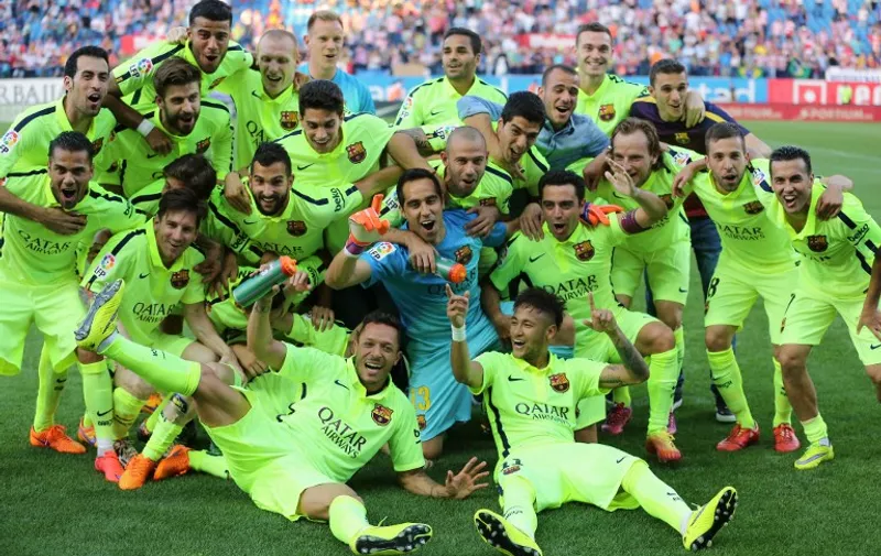 Barcelona's players celebrate winning the championship and the game after the Spanish league football match Club Atletico de Madrid vs FC Barcelona at the Vicente Calderon stadium in Madrid on May 17, 2015. AFP PHOTO/ CESAR MANSO