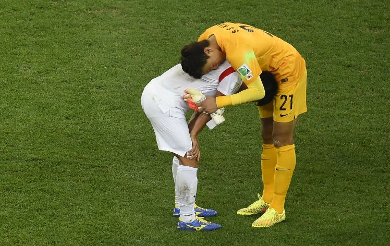 South Korea's goalkeeper Kim Seung-Gyu (R) and a teammate react after being defeated at the end of a Group H football match between South Korea and Belgium at the Corinthians Arena in Sao Paulo during the 2014 FIFA World Cup on June 26, 2014. Belgium won 1-0.   AFP PHOTO/ FABRICE COFFRINI