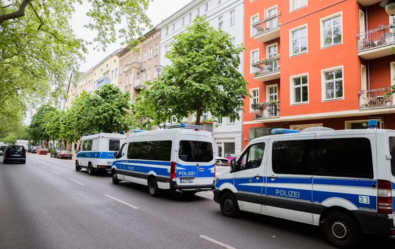 24 May 2023, Berlin: Police vehicles during a house search in Berlin-Kreuzberg. Photo: Christoph Soeder/dpa - ATTENTION: license plate of parked private car pixelated in background (Photo by Christoph Soeder / DPA / dpa Picture-Alliance via AFP)