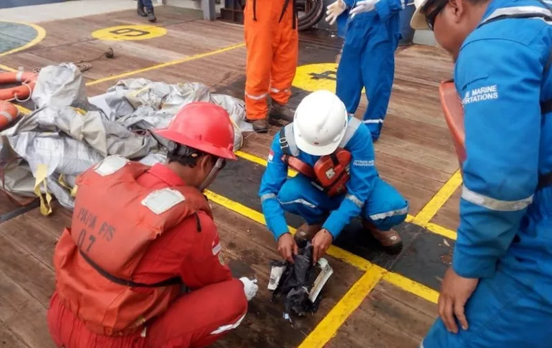This handout photo taken by Pertamina Hulu Energy and released on October 29, 2018 via the Twitter account of Sutopo Purwo Nugroho from Indonesia's National Disaster Mitigation Agency shows personnel looking at items believed to be from the wreckage of the Lion Air flight JT 610, recovered off the coast of Indonesia's Java island after the Boeing crashed into the sea. - The Indonesian Lion Air plane carrying 188 passengers and crew crashed into the sea on October 29, officials said, moments after it had asked to be allowed to return to Jakarta. (Photo by Handout / various sources / AFP) / -----EDITORS NOTE --- RESTRICTED TO EDITORIAL USE - MANDATORY CREDIT "AFP PHOTO / Pertamina Hulu Energy via National Disaster Mitigation Agency" - NO MARKETING - NO ADVERTISING CAMPAIGNS - DISTRIBUTED AS A SERVICE TO CLIENTS - NO ARCHIVES / ìThe erroneous mention[s] appearing in the metadata of this photo by Handout has been modified in AFP systems in the following manner: [This handout photo taken by Pertamina Hulu Energy and released on October 29, 2018 via the Twitter account of Sutopo Purwo Nugroho] instead of [This handout photo taken and released on October 29, 2018 via the Twitter account of Sutopo Purwo Nugroho]. Please immediately remove the erroneous mention[s] from all your online services and delete it (them) from your servers. If you have been authorized by AFP to distribute it (them) to third parties, please ensure that the same actions are carried out by them. Failure to promptly comply with these instructions will entail liability on your part for any continued or post notification usage. Therefore we thank you very much for all your attention and prompt action. We are sorry for the inconvenience this notification may cause and remain at your disposal for any further information you may require.î