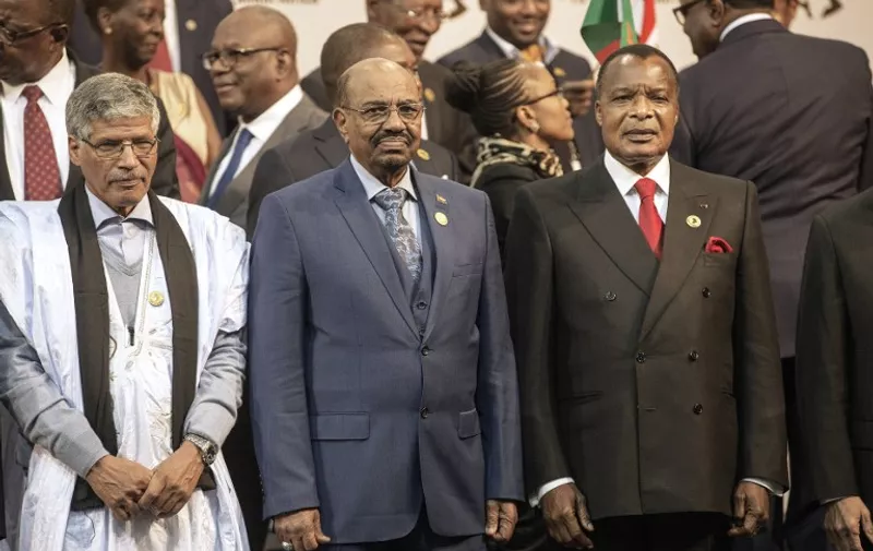 Sudanese President Omar al-Bashir (C), flanked by Congo's President Denis Sasso-Nguesso (R) and a Sahrawi representative, poses for a group photograph of leaders at the 25th African Union Summit in Sandton South Africa on June 14, 2015. Sudanese President Omar al-Bashir joined a group photograph of leaders at the African Union summit in Johannesburg on June 14 despite the International Criminal Court calling for him to be arrested at the event. Wearing a blue suit, he stood in the front row for the photograph along with South African host President Jacob Zuma and Zimbabwe's President Robert Mugabe, who is the chair of the 54-member group. AFP PHOTO / GIANLUIGI GUERCIA