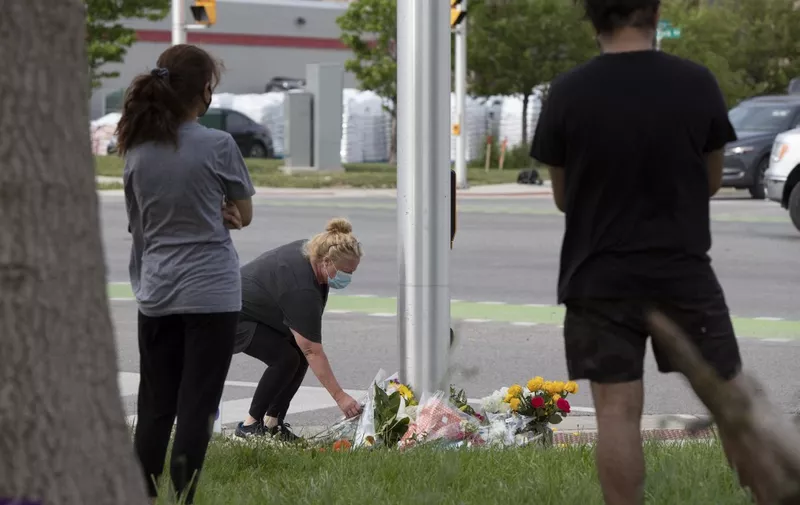 A woman brings flowers and pays her respects at the scene where a man driving a pickup truck struck and killed four members of a Muslim family in London, Ontario, Canada on June 7, 2021. - A man driving a pick-up truck slammed into and killed four members of a Muslim family in the south of Canada's Ontario province, in what police said Monday was a "premeditated" attack.
A 20-year-old suspect wearing a vest "like body armor" fled the scene after the attack on Sunday evening, and was arrested at a mall seven kilometers (four miles) from the intersection in London, Ontario where it happened, said Detective Superintendent Paul Waight. (Photo by Nicole OSBORNE / AFP)